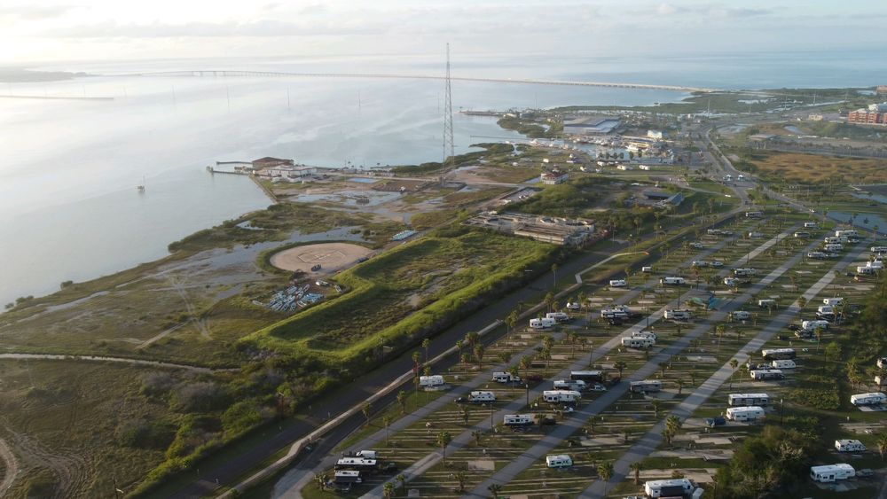 Aerial view of caravans arranged at a coastal campsite